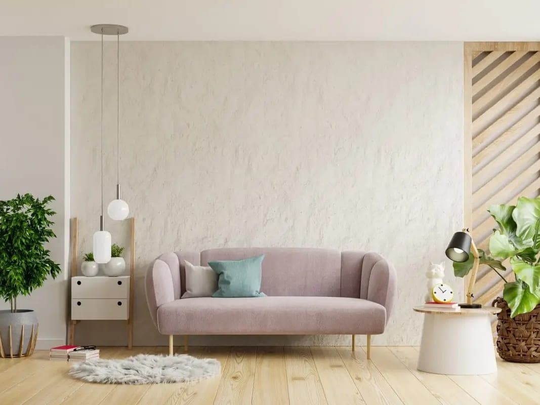 Séjour vide et lumineux : canapé rose poudré, plantes vertes et parquet clair